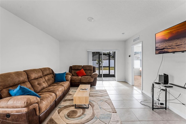 tiled living room featuring a textured ceiling