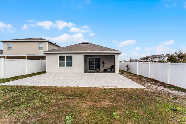 back of house featuring a lawn and a patio area