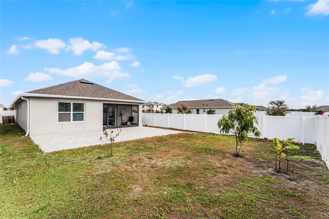 rear view of property featuring a yard and a patio