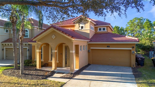 mediterranean / spanish house with covered porch and a garage