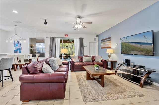 living room with light tile patterned floors and ceiling fan with notable chandelier