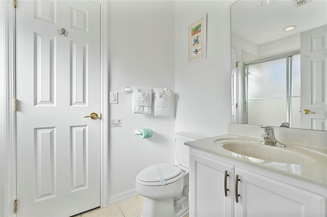 bathroom featuring tile patterned floors, vanity, a shower with shower door, and toilet