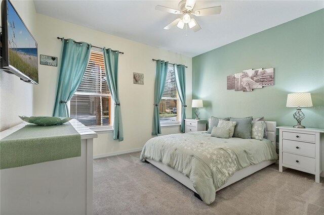 carpeted bedroom with multiple windows and ceiling fan