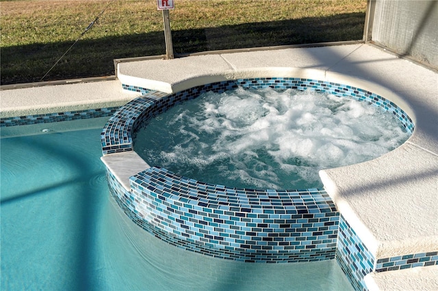 view of pool featuring a yard and an in ground hot tub