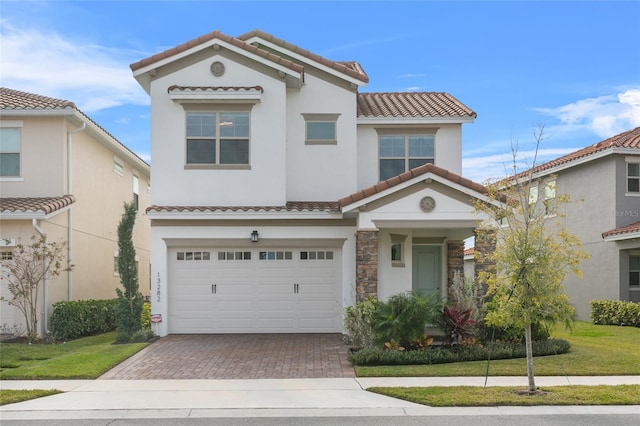 mediterranean / spanish-style home featuring a garage and a front yard