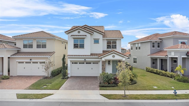 mediterranean / spanish home with a garage and a front lawn