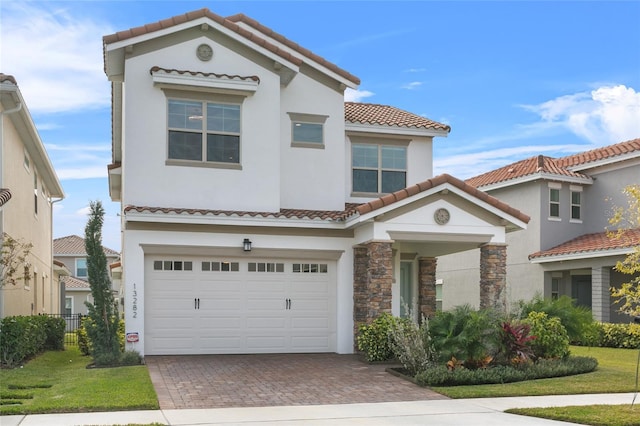 mediterranean / spanish home featuring a front lawn and a garage