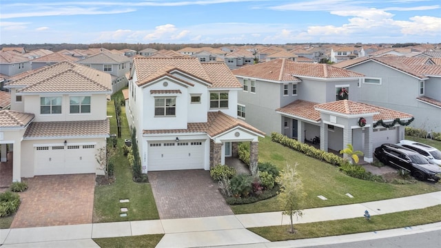 mediterranean / spanish-style house with a garage and a front lawn