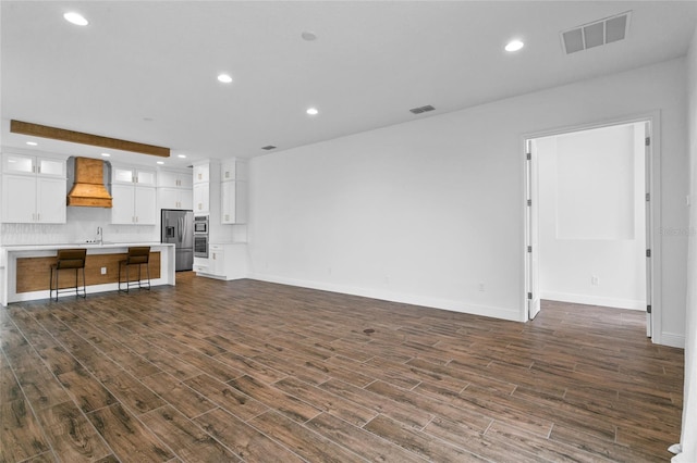 unfurnished living room featuring sink