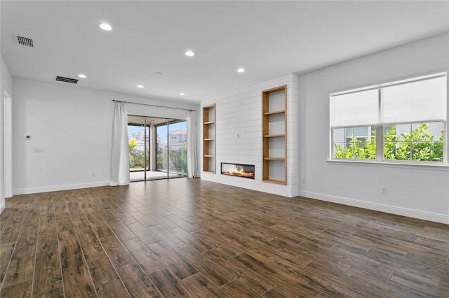 unfurnished living room featuring built in shelves and a fireplace