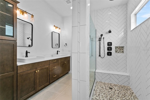 bathroom with tile patterned floors, vanity, and tiled shower