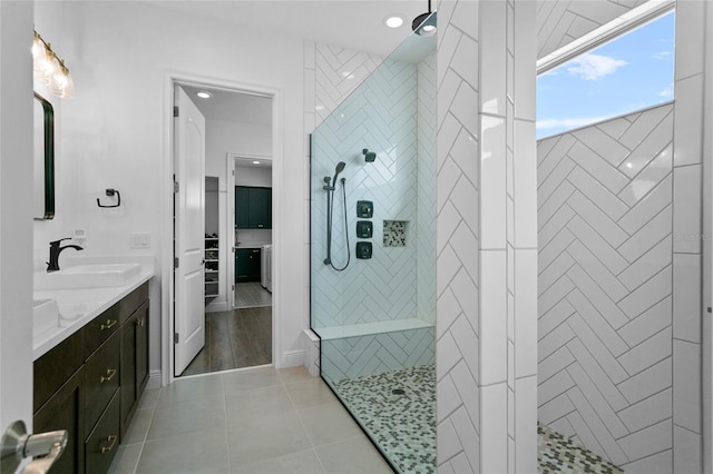 bathroom featuring tile patterned floors, vanity, and a tile shower