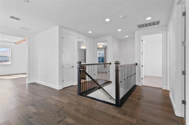 hall with dark hardwood / wood-style floors and a textured ceiling