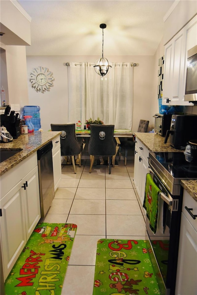 kitchen featuring appliances with stainless steel finishes, light tile patterned floors, white cabinetry, and pendant lighting