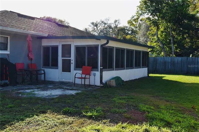 back of house featuring a sunroom and a yard