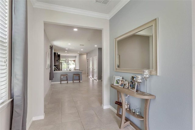 hall featuring crown molding and light tile patterned flooring