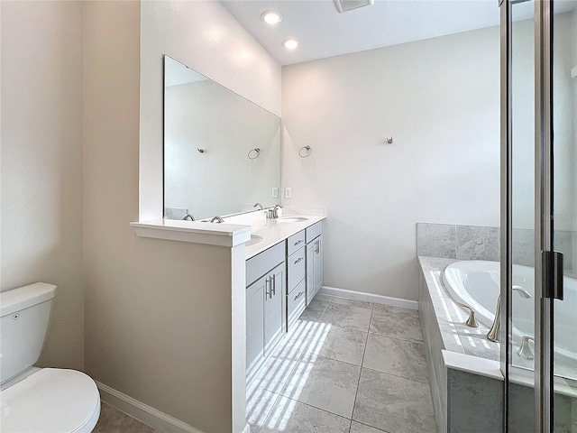 bathroom featuring vanity, tiled bath, and toilet