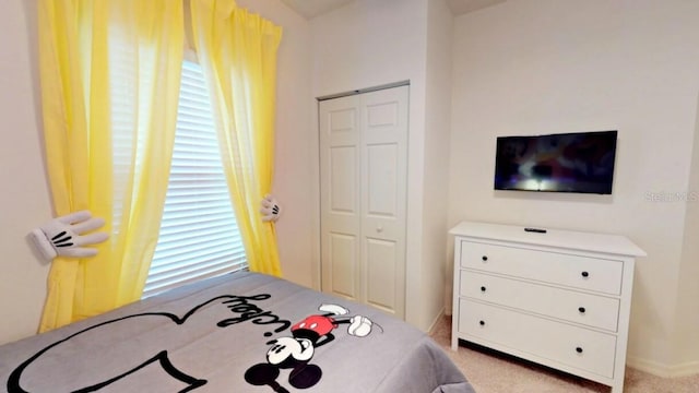 bedroom with light carpet and a closet