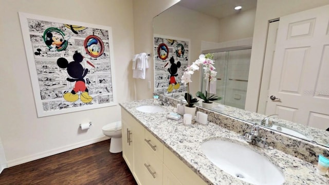 bathroom featuring vanity, hardwood / wood-style flooring, toilet, and a shower with door