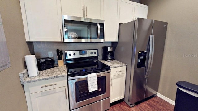 kitchen with decorative backsplash, light stone countertops, stainless steel appliances, dark hardwood / wood-style floors, and white cabinetry