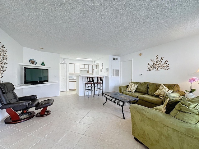 tiled living room featuring a textured ceiling