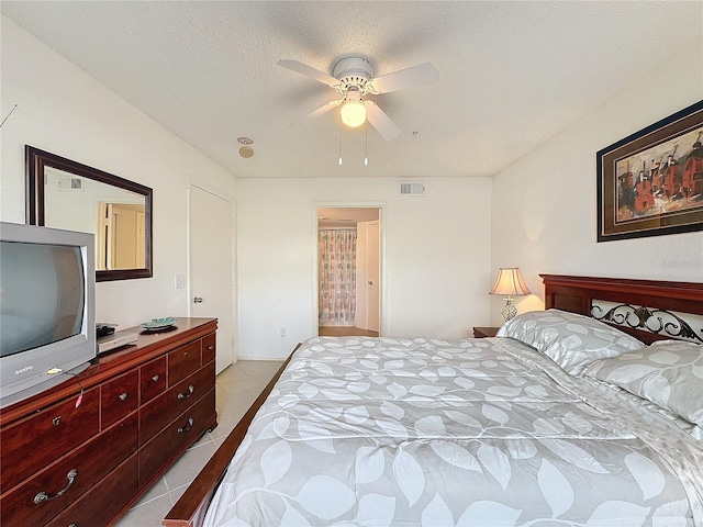 tiled bedroom featuring a textured ceiling and ceiling fan