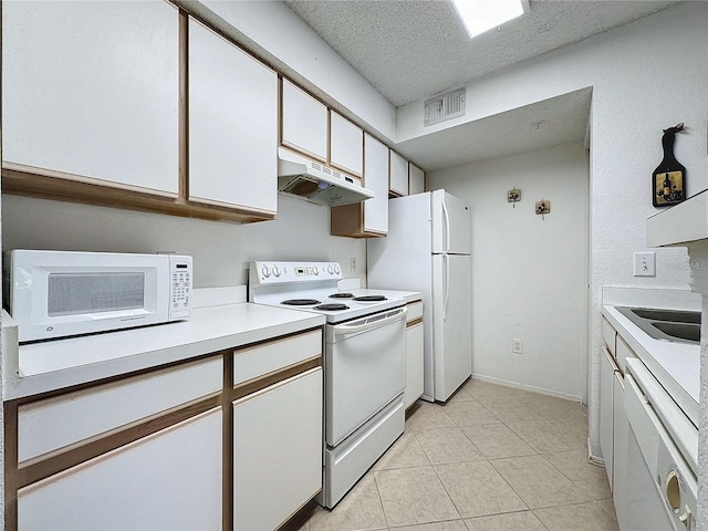 kitchen with sink, light tile patterned floors, a textured ceiling, white appliances, and white cabinets