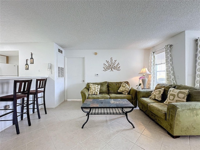 living room featuring light tile patterned floors and a textured ceiling