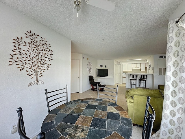 dining room with ceiling fan and a textured ceiling