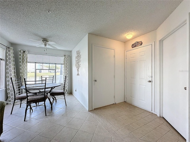 dining area featuring ceiling fan, light tile patterned floors, and a textured ceiling