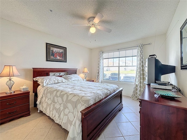 bedroom featuring ceiling fan, light tile patterned floors, and a textured ceiling