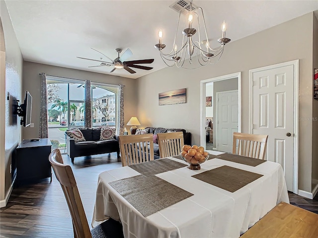 dining space with dark wood-type flooring and ceiling fan with notable chandelier