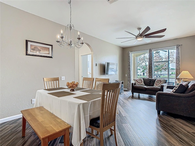 dining area featuring ceiling fan with notable chandelier and dark wood-type flooring