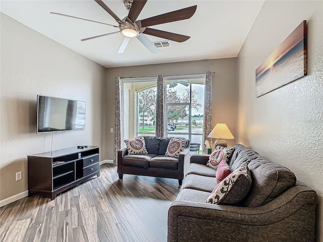 living room featuring ceiling fan and wood-type flooring