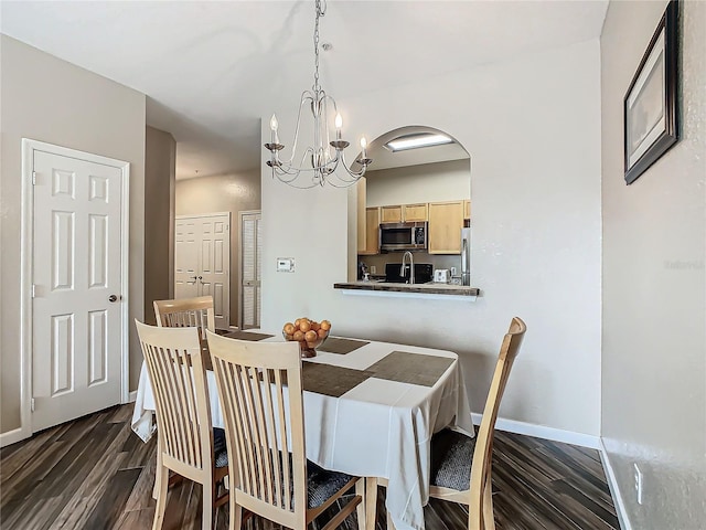 dining room with dark hardwood / wood-style floors and a notable chandelier