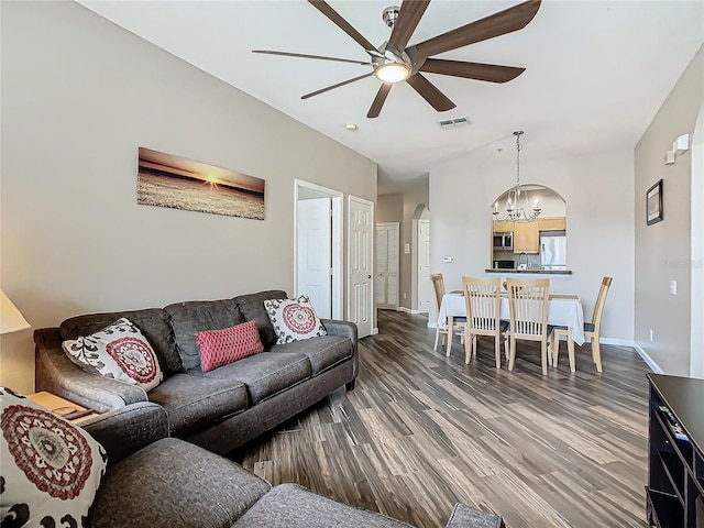 living room with ceiling fan with notable chandelier and dark wood-type flooring