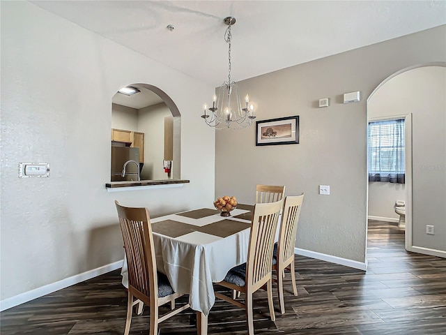 dining room with dark hardwood / wood-style floors and a chandelier