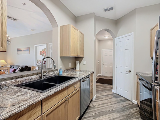 kitchen featuring light stone countertops, sink, light hardwood / wood-style flooring, stainless steel dishwasher, and light brown cabinetry