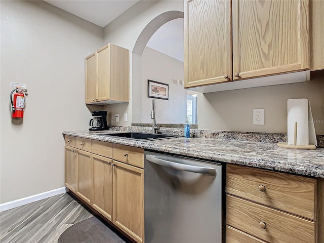 kitchen with light brown cabinetry, light stone countertops, sink, and stainless steel dishwasher