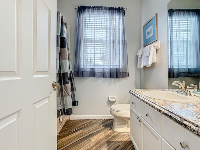 bathroom featuring wood-type flooring, vanity, toilet, and plenty of natural light