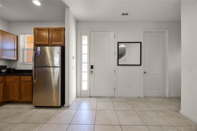 kitchen featuring light tile patterned flooring and stainless steel refrigerator