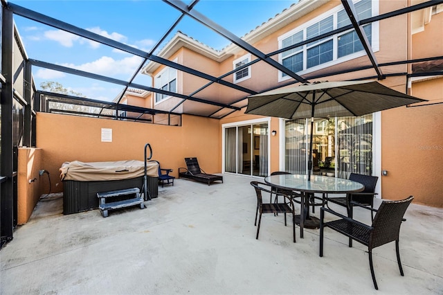 view of patio featuring a lanai and a hot tub