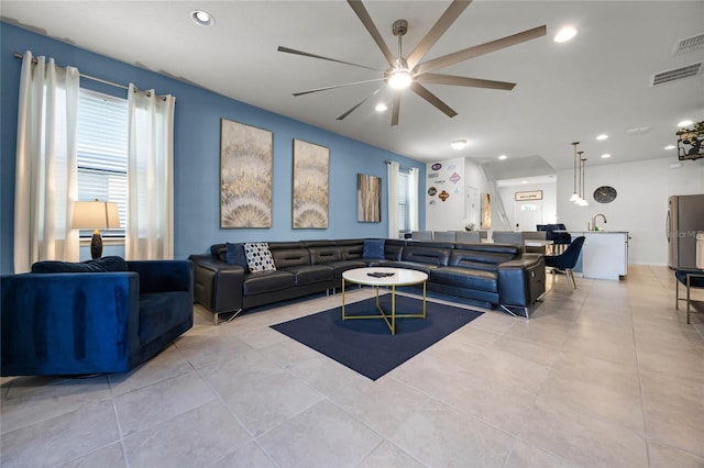 tiled living room featuring ceiling fan and sink