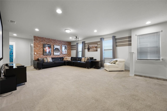 carpeted living room featuring brick wall