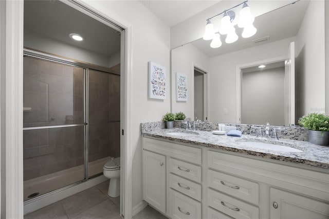 bathroom with toilet, vanity, tile patterned floors, and a shower with shower door