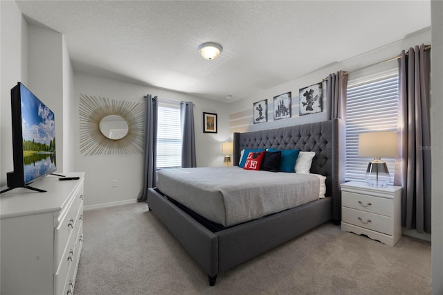 bedroom featuring light carpet and a textured ceiling