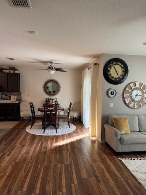 dining room with hardwood / wood-style flooring, a textured ceiling, and ceiling fan