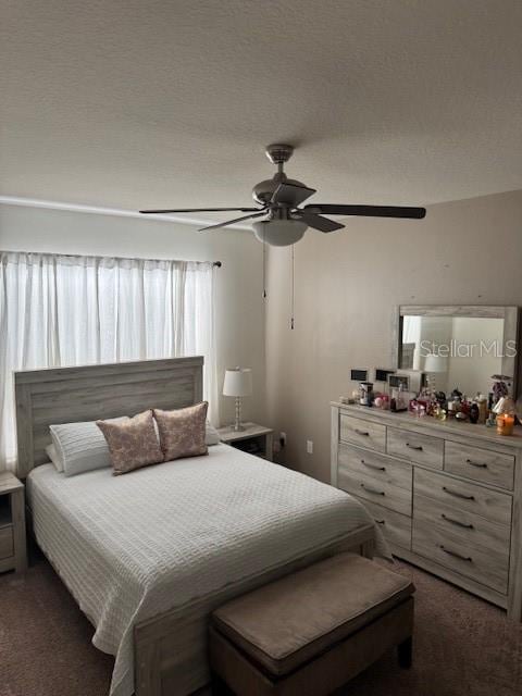 bedroom featuring ceiling fan and dark carpet