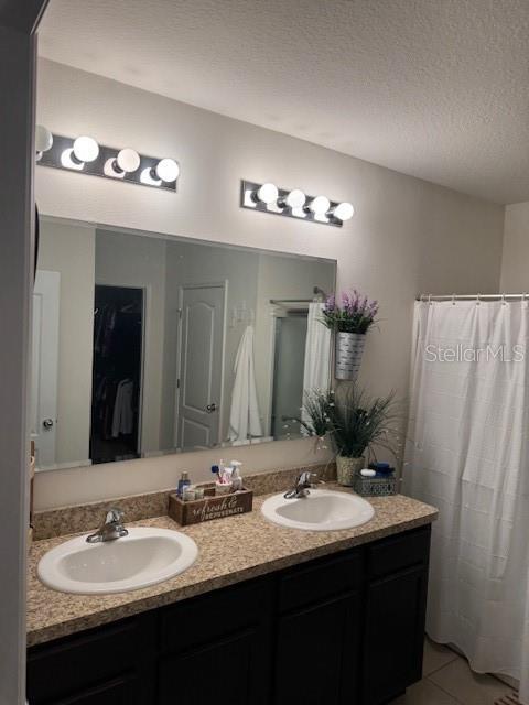 bathroom featuring tile patterned flooring, vanity, and a textured ceiling