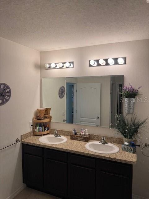 bathroom with vanity, tile patterned flooring, and a textured ceiling